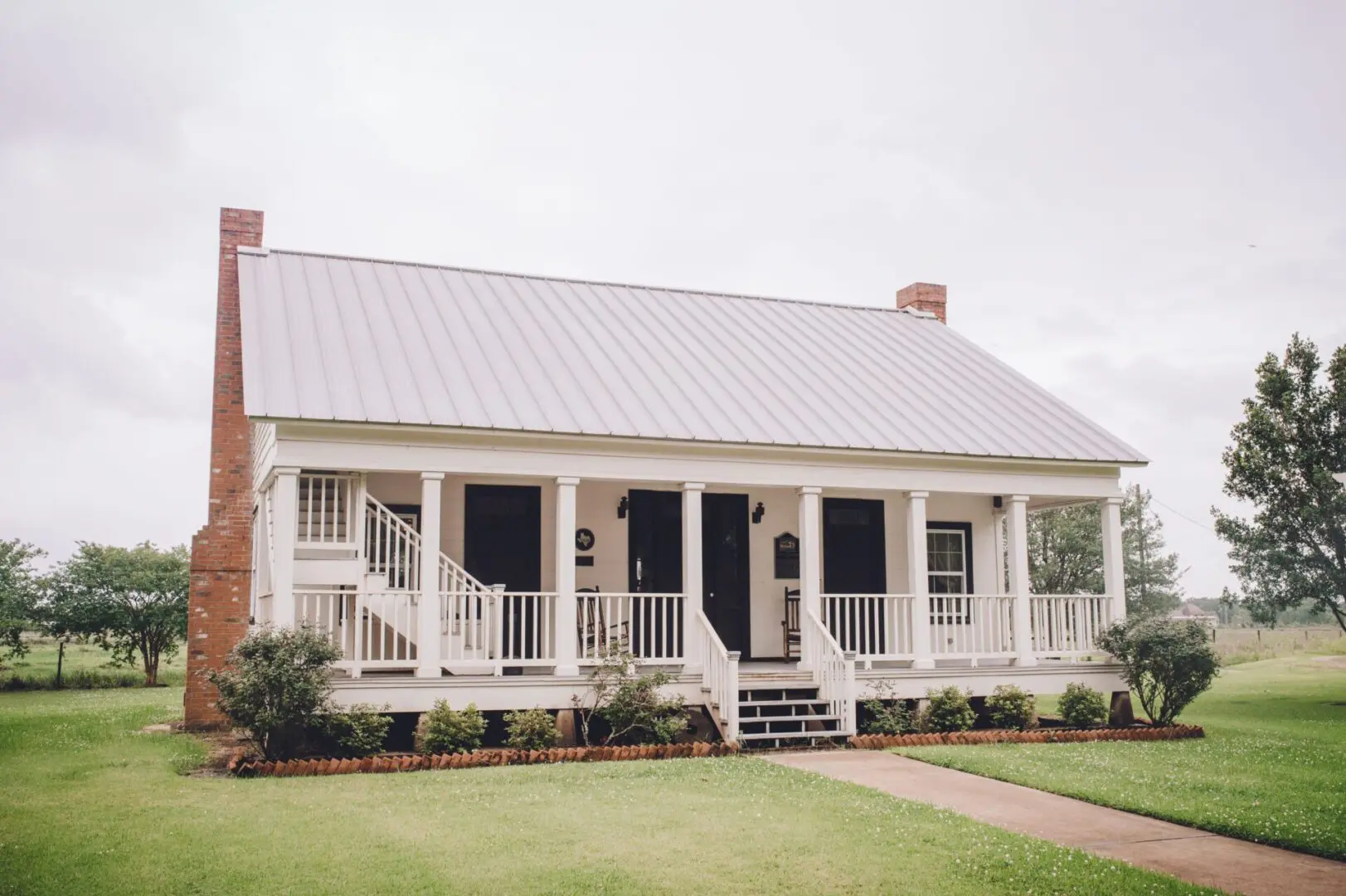 white house with brick roof and lawn wedding 18